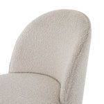 Macro detail of boucle fabric texture on chair’s softly rounded backrest