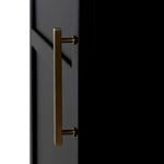 Close-up of slim brushed brass vertical door handle mounted on matte black cabinet door.