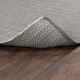 Corner of rug slightly folded up to show underside weave and edge finishing