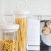 Small Bianca canister with pasta in foreground and cooking books behind on kitchen counter