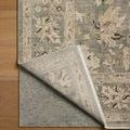 Rug corner flipped over showcasing weave on underside and thickness against wooden flooring