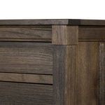 Close-up of top corner showing layered wood trim and contrast between darker and lighter wood tones
