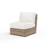 Side angle of armless chair highlighting the thick seat and back cushions and woven wicker base
