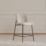 Early stool in a neutral room setting on light rug with paneled wall background