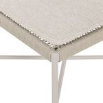 Close-up of chair seat corner showing fabric cushion over tightly wrapped wicker seat frame