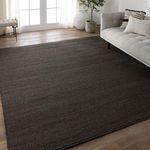 Charcoal rug styled in a bright living room with light hardwood floors and modern beige sofa