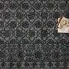 Top view of Cecelia rug with stacked tray and vintage photos, highlighting scale and room styling