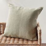 Otis Pinstripe Pillow styled on woven rattan chair showcasing neutral colors in a natural room setting