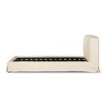 Side elevation of slipcovered bed frame without mattress showing wooden slats