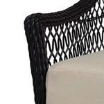 Close-up showing rounded edge of resin wicker armrest beside tightly woven beige seat cushion