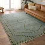 Overhead view of stacked rugs with varying geometric and medallion designs in muted color palette