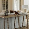 Two Foundation Candleholders placed on console table behind sofa in bright living room with open book and lamp