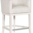 Ian stool angled view showing armrests and tapered wood legs with silver metal footrest