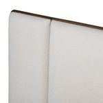Close view of upper join line where two padded fabric panels meet on winged headboard