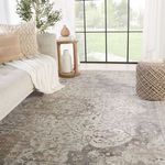 Vintage medallion rug styled in bright room next to neutral sofa and woven ottoman