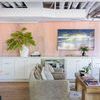 Modern seating area with Avin rug under armchairs, wooden coffee table, against orange wall