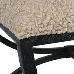 Close-up of textured aged black iron frame with plush latte shearling corner detail