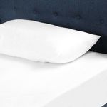 Close-up of white pillow resting against indigo button-tufted headboard