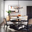 Pellman Chandelier above round white dining table in bright room with dark wood floor and abstract wall art