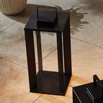 Hanley Solar LED Lantern styled outdoors on tiled floor casting warm light at dusk