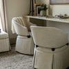 Two Brewer chairs arranged under desk in softly lit room with rug and decorative accessories
