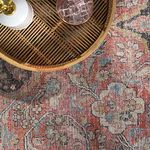 Overhead close-up of rug pattern under a rattan tray with glass and white ceramic container