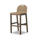 Bar stool angled view showing woven seat and wooden legs with footrest