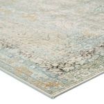 Close-up showing rug's textured surface and detailed border in green, gold, and light blue hues