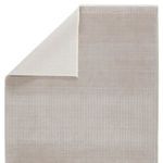 Rug folded at corner to reveal smooth light gray backing fabric