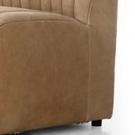 Close-up of banquette’s lower side showing leather grain, stitching, and short black feet