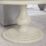 Close view of pedestal base from side showing carvings and wood texture with carpeted floor background