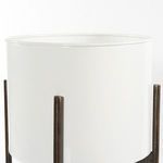 Close-up of the smooth white planter surface and dark textured bronze leg detail