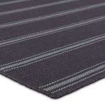 Close-up corner angle of striped navy and light blue rug highlighting texture and yarn quality