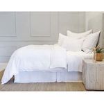 Side view of bed fully made with Blake White/Ocean Duvet and pillows against gray paneled wall