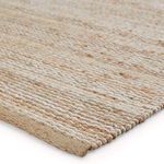 Close-up angled view showing woven texture and layered wool and jute fibers in beige and ivory tones