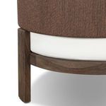 Close-up of chair base leg showing dark stained wood grain and cushion underside