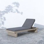 Leroy Outdoor Chaise on stone patio with shadows and light textured grey finish