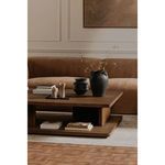 Casey Coffee Table styled with vases, candles, and stacked books in a modern living room with brown sofa