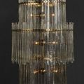 Electra chandelier front view against black background with lights on inside glass bars