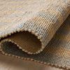 Folded corner close-up highlighting the rug’s handwoven weave and jute-cotton fiber blend