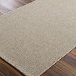 Close-up angle of Birdie rug on wood floor showing the detailed woven texture and flat surface