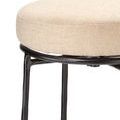 Close-up of beige upholstered seat fabric texture and iron base connection