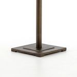 Close-up of square metal base and cylindrical pedestal in antique brass finish