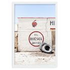 Aerial photo of a white brick wall with vintage red and black Route 66 signage, Indian head, and two tires against the wal...
