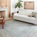Wynter Ocean Silver rug placed in living room with white couch, wood floor, and modern decor