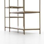 Repeating detail of three marble shelves with slim brass frame edges