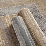 Partial rug roll showing backside and pile texture with visible gray and gold abstract stripe pattern