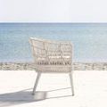 Dana Rope Dining Chair back left 3/4 view showing woven frame and tapered legs on wooden deck by ocean