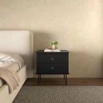 Reagan nightstand styled in bedroom next to beige upholstered bed and textured rug