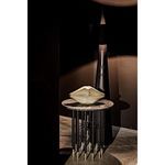 Moray Floor Lamp positioned behind a round side table with decorative sculpture in a dimly-lit room